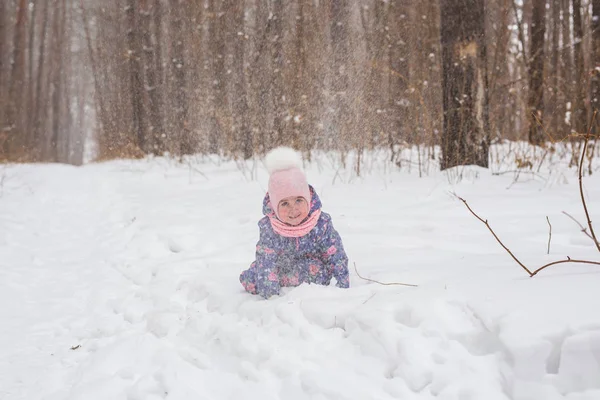 Семья, дети и природа - маленькая девочка развлекается в зимнем парке — стоковое фото