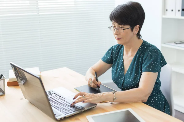 Fotoğraf ve grafik sanat kavramı - grafik tasarımcı parlak bir ofiste onun tablet kullanma.