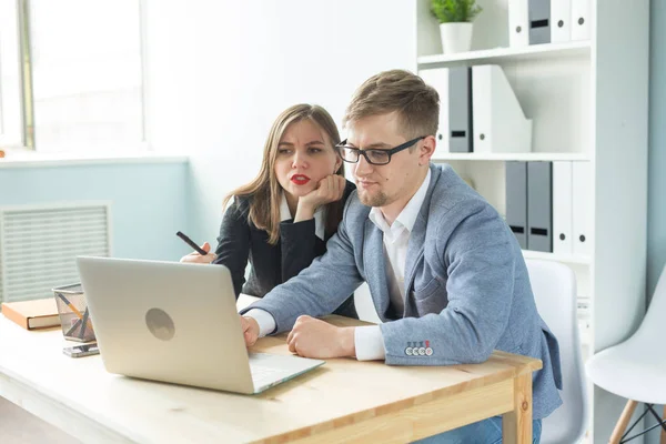 Gente de negocios, trabajo en equipo y concepto de oficina - Hombre y mujer colega sentado en la mesa y discutiendo un interesante proyecto de startup . — Foto de Stock