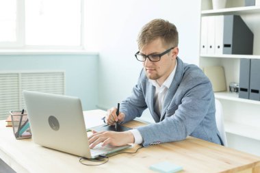 Tasarımcı, sanatçı ve web tasarım konsepti - ofiste dijital kalem tablet ve dizüstü bilgisayar kullanan genç adam portresi