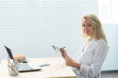 Çalışma, iş, teknoloji ve insan kavramı - Not yazma ve gülümseyen genç kadın