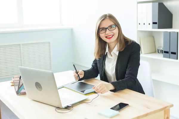 Illustrator, web designer and artist concept - Graphic designer using her pen tablet in a bright office