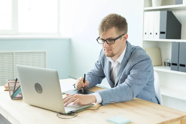Designer, artist and web design concept - Portrait of young man using digital pen tablet and laptop in the office — Stock Photo, Image