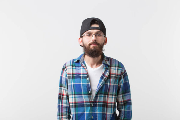 Beauty, fashion and people concept - Portrait of a young bearded hipster stylish guy over white background.