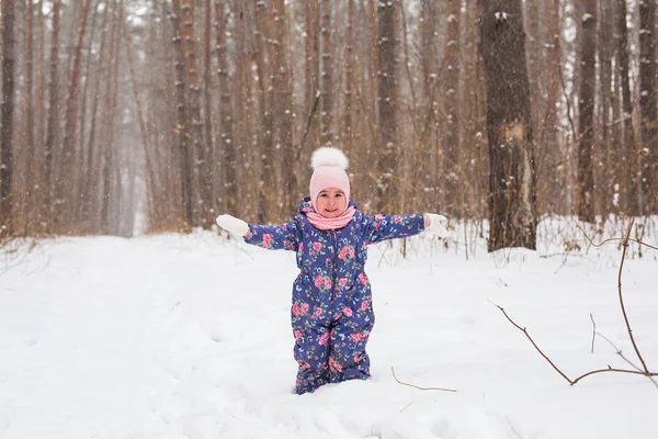 Дети, зима и природа - закройте восхитительного малыша, играющего со снегом в парке — стоковое фото