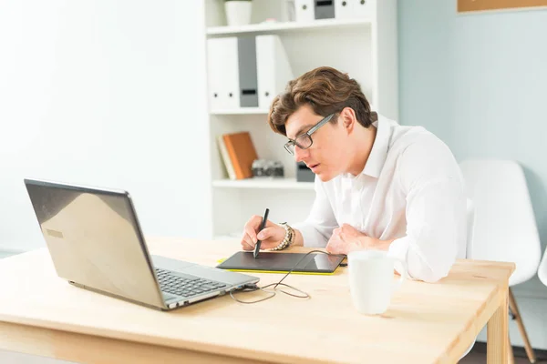 Business-, Design- und People-Konzept - schöner junger Mann im weißen Hemd mit Grafiktafel am Holztisch — Stockfoto