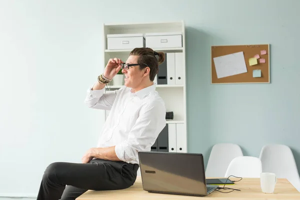 Business, humor and people concept - Young man in white shirt sitting on wooden table