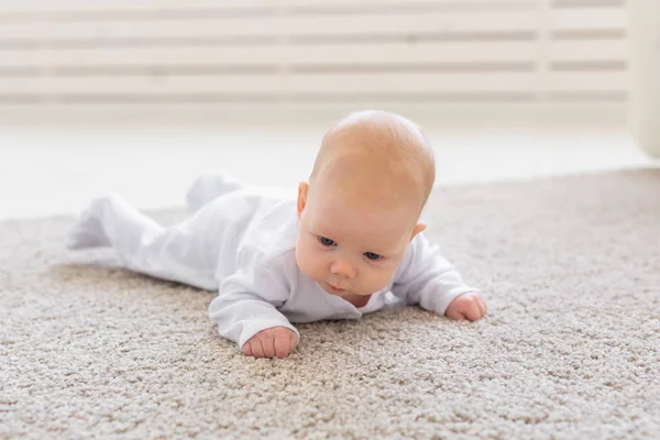 童年、婴儿和人的概念--躺在地板上的小婴儿 — 图库照片