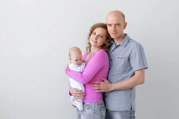 Concept de famille, d'enfance et de parentalité - Père, mère tenant bébé mignon sur fond blanc avec espace de copie — Photo