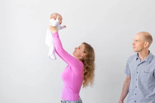 Концепція сім'ї, дитинства та батьківства - батько, мати тримає милу дитину на білому тлі — стокове фото