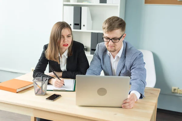 Concepto de empresa, trabajo en equipo y personas: hombre serio y mujer atractiva que trabaja en el proyecto en la oficina — Foto de Stock