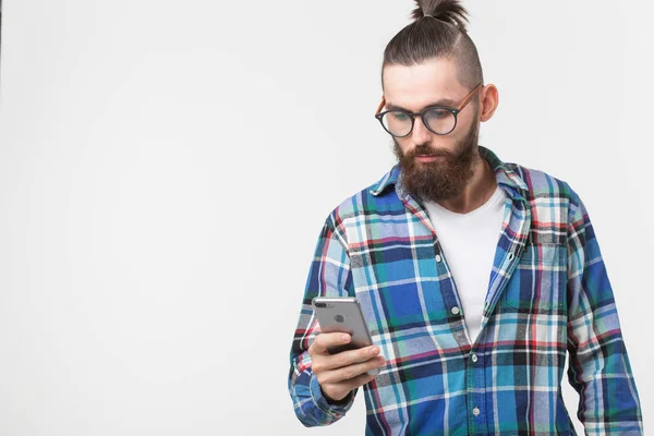 Технологии, мода и концепция людей - Крутой человек с бородой с помощью телефона на белом фоне с копировальным пространством — стоковое фото