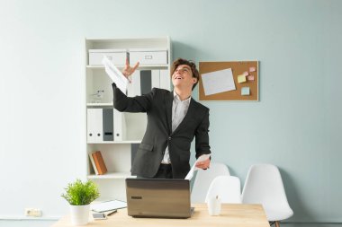 İş, mizah ve insanlar kavramı - yaprak kağıt Office kadar yakışıklı ve genç bir adam takım atar