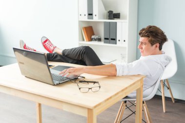 Sakin ol, şaka ve iş kavramı - eğleniyor, bu bir başlangıç ile masada oturan yakışıklı adam.