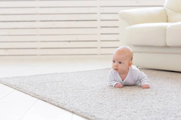 Barndom, spädbarn och personer koncept - liten baby som ligger på golvet — Stockfoto