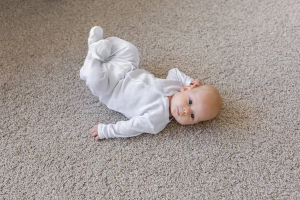 Niño, la infancia y el concepto de bebé - Bebé bonito tumbado en el suelo — Foto de Stock