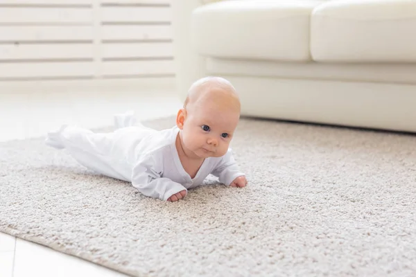 Baby, childhood, people concept - Portrait of a crawling baby on the floor
