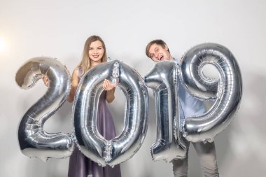 Yeni yıl, kutlama ve tatil kavramı - komik aşk çift holding yeni yıl için gümüş balon beyaz zemin üzerine yapılan 2019 imzalamak