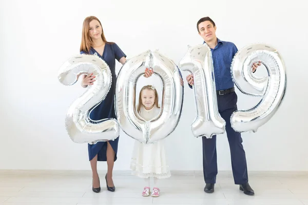 Nuevo 2019 Año viene concepto - Familia feliz están sosteniendo números de color plata en el interior . — Foto de Stock