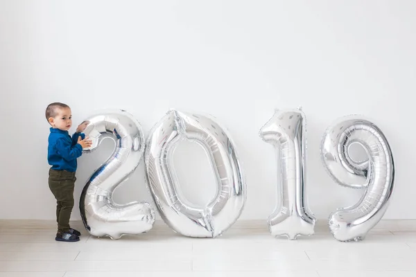 Nuevo 2019 Año viene concepto - Feliz madre e hijo con números de color plata en el interior . — Foto de Stock