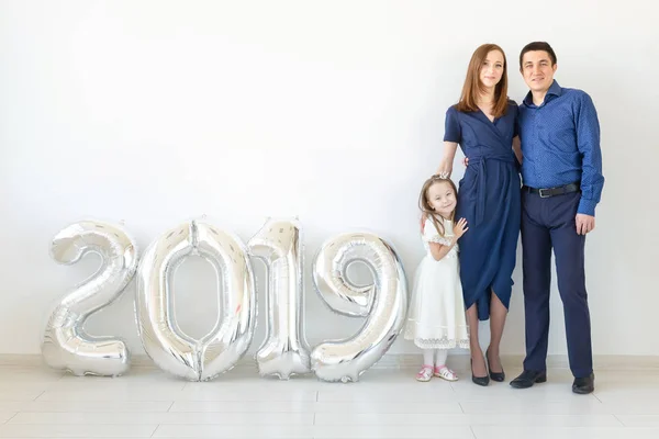 Novo 2019 Ano está chegando conceito - Família feliz que está perto de números coloridos prata dentro de casa . — Fotografia de Stock