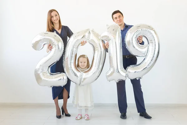 Nuevo 2019 Año viene concepto - Familia feliz están sosteniendo números de color plata en el interior . — Foto de Stock