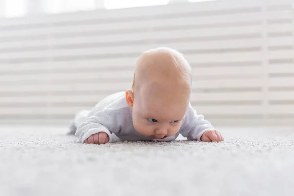 Childhood, infant and people concept - small baby lying on the floor — Stock Photo, Image