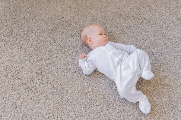 Familia, concepto de la infancia - Primer plano retrato de bebé bonito yacen en el suelo — Foto de Stock