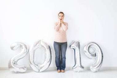 Yeni 2019 yılı önümüzdeki - gümüş renkli numaraları kapalı duran sürpriz genç kadın bir kavramdır.