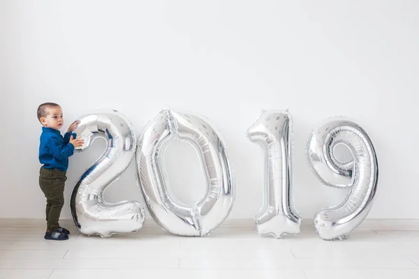 Nuevo 2019 Año viene concepto - Niño pequeño con números de color plata en el interior . — Foto de Stock