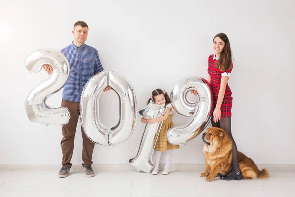 Nuevo 2019 Año viene concepto - Familia con perro están sosteniendo números de color plata en whithe habitación — Foto de Stock