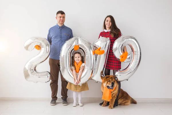 Nuevo 2019 Año viene concepto - Familia con perro están sosteniendo números de color plata en whithe habitación — Foto de Stock