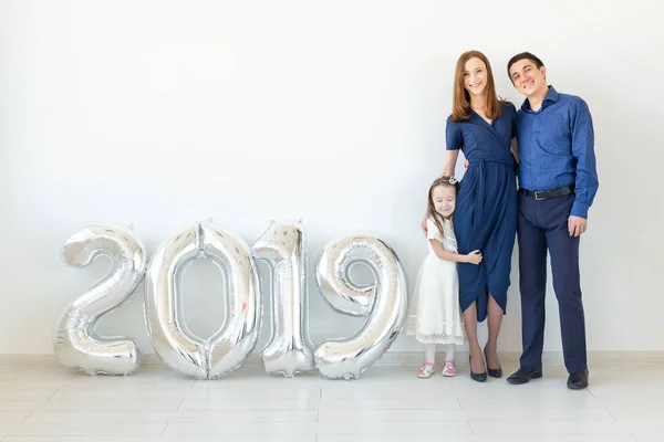Nuevo 2019 Año viene concepto - Familia feliz de pie cerca de los números de color plata en el interior . — Foto de Stock