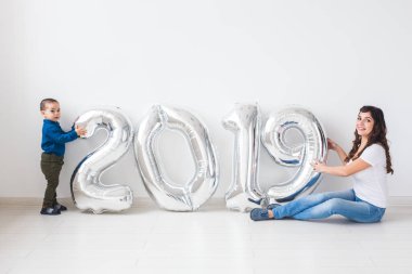 Yeni 2019 yılı konsept - mutlu anne ve oğlu gümüş renkli numaralarla kapalı geliyor.