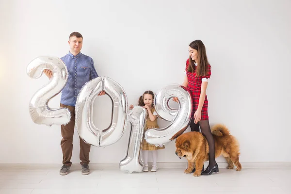 Nuevo 2019 Año viene concepto - Familia con perro están sosteniendo números de color plata en whithe habitación —  Fotos de Stock