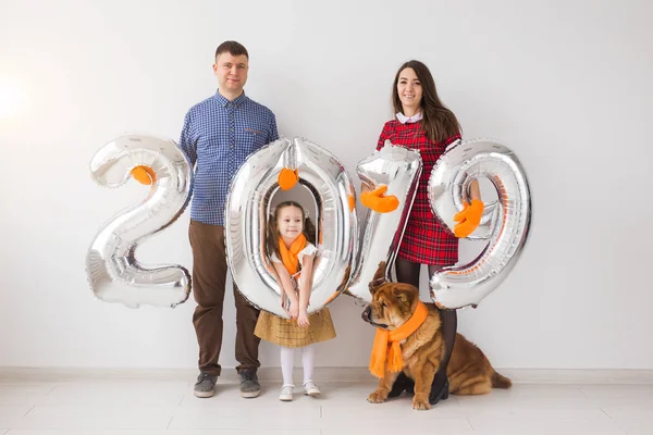 Nuevo 2019 Año viene concepto - Familia con perro están sosteniendo números de color plata en whithe habitación —  Fotos de Stock