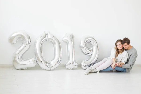 Nuevo 2019 Año viene concepto - amar a los hombres y mujeres jóvenes con números de color plata — Foto de Stock