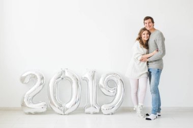 Yeni 2019 yılı konsept - romantik genç adam ve kadın beyaz arka plan üzerinde gümüş renkli numaralarla geliyor