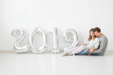 Yeni yıl, kutlama ve tatil kavramı - aşk çift işareti yeni yıl için gümüş balon beyaz zemin üzerine yapılan 2019