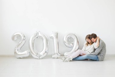 Yeni 2019 yılı konsept - romantik genç adam ve kadın beyaz arka plan üzerinde gümüş renkli numaralarla geliyor
