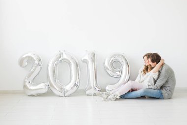 Yeni 2019 yılı konsept - sevgi dolu genç adam ve kadın gümüş renkli numaraları ile geliyor