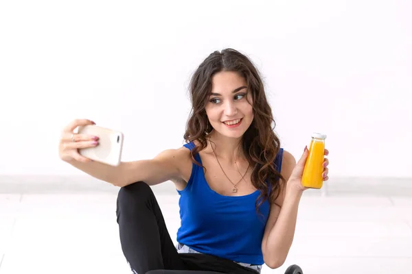 Stile di vita sano, persone e concetto di sport - Donna che si fa selfie e tiene succo di frutta — Foto Stock