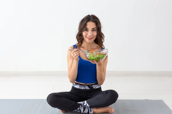 Mode de vie sain, personnes et concept sportif - Femme de yoga avec un bol de salade de légumes — Photo