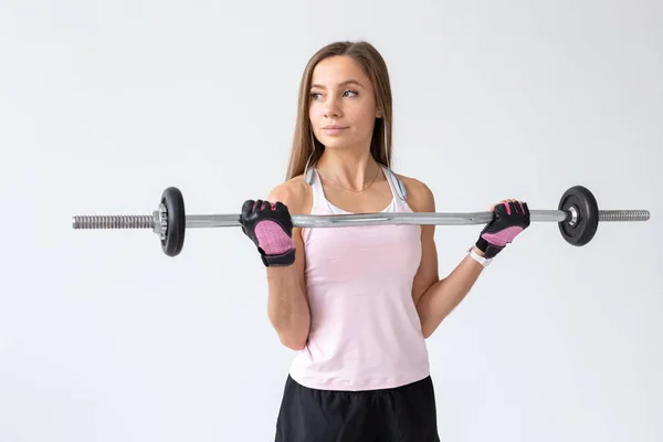 Mode de vie sain, fitness, personnes et concept sportif - Entraînement de jeune femme avec barre de corps sur fond blanc — Photo