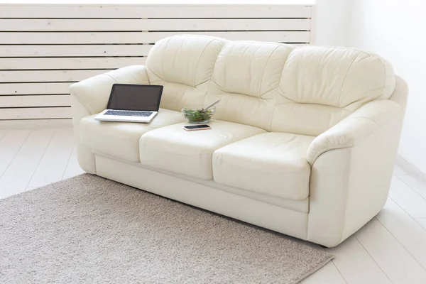 Business- und Innenraumkonzept - Blick auf ein weißes Wohnzimmer mit Sofa, offenem Laptop, Wohnbereich — Stockfoto