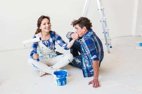 People, redecoration and relationship concept - Young funny couple doing renovation in new apartment — Stock Photo, Image