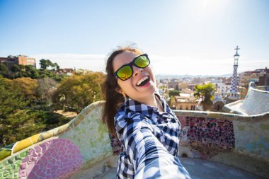 Seyahat ve tatil kavramı - mutlu kadın selfie portre ile smartphone Park Guell, Barselona, İspanya, yapma.