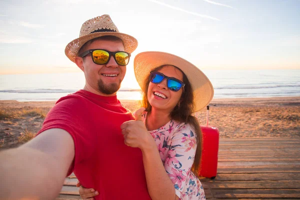 Cestování a dovolená koncept - šťastný mladý pár v lásce bere selfie portrét na pláži — Stock fotografie