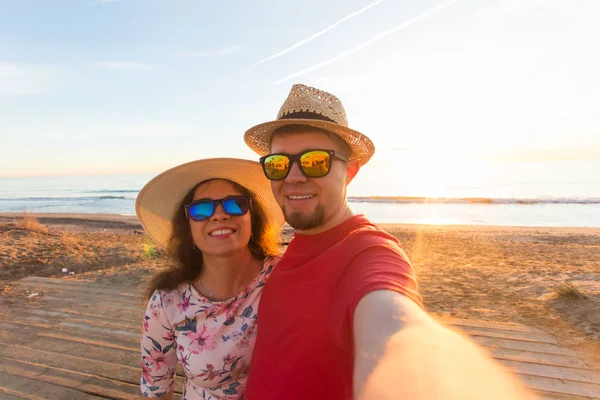 Ταξίδια και διακοπές και καλοκαίρι έννοια - υπέροχο ζευγάρι λαμβάνοντας αυτοπορτρέτα σε μια παραλία — Φωτογραφία Αρχείου