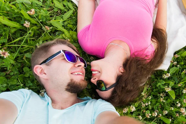 Conceito de amor, romântico e ternura - Feche a selfie de um casal jovem e atraente que estabelece na grama verde, vista superior — Fotografia de Stock